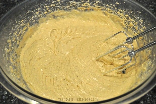 The batter is combined for apple cider bundt cake with an electric mixer.
