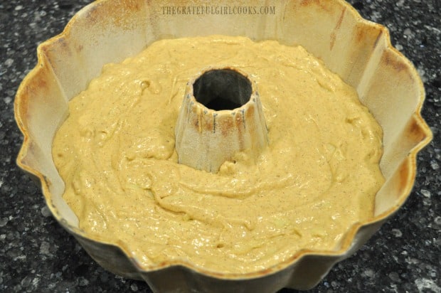 The batter for apple cider bundt cake is placed in a greased/floured bundt pan.