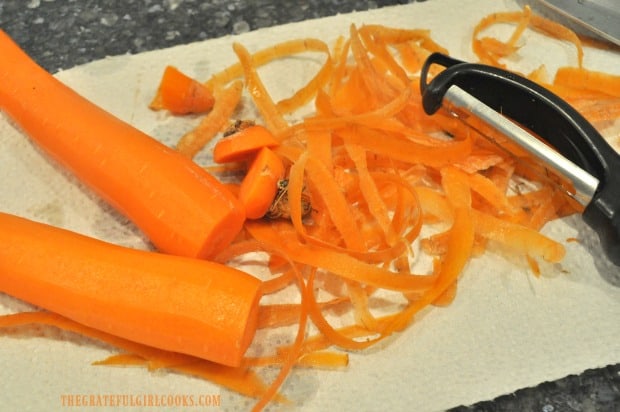Using a vegetable peeler to peel carrots for spiralized carrot salad.