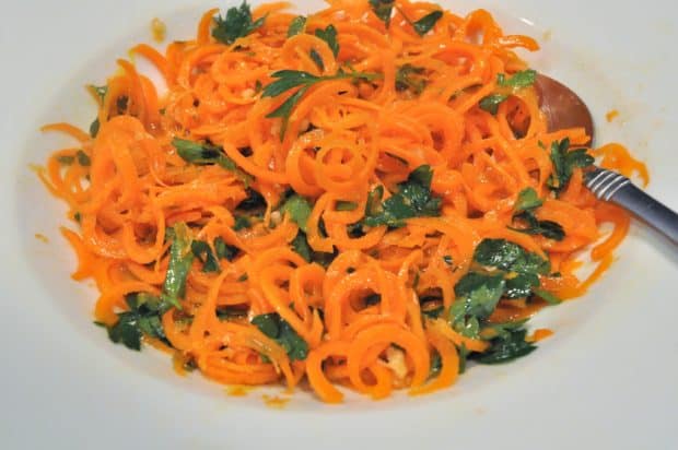 Spiralized carrot salad in white bowl.