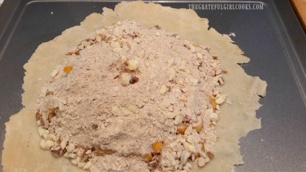 Streusel topping is added to peach galette before baking.