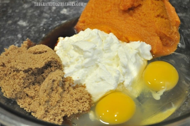 Eggs, pumpkin, Greek yogurt and brown sugar are mixed to make batter for pumpkin chocolate chip muffins.