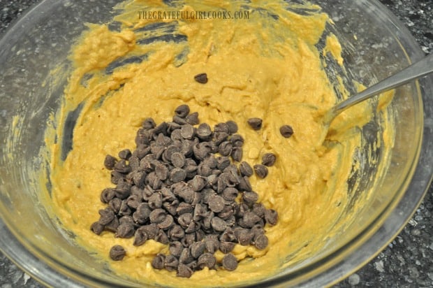 Chocolate chips are added to pumpkin muffin batter.