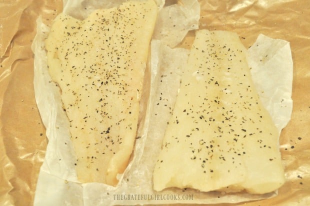 Cod fillets are seasoned with salt and pepper before roasting.