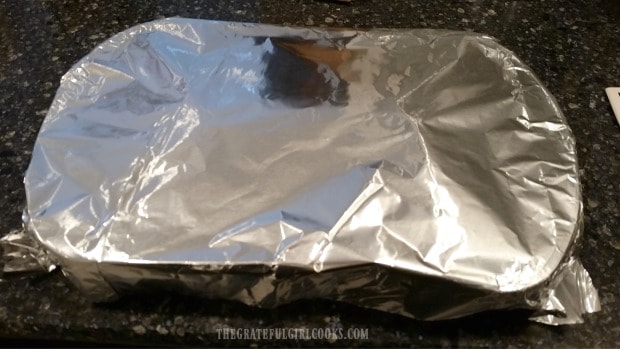 Baking dish with spaghetti squash is covered with foil before baking.