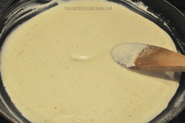 The alfredo sauce for the bacon parmesan spinach quiche has thickened.