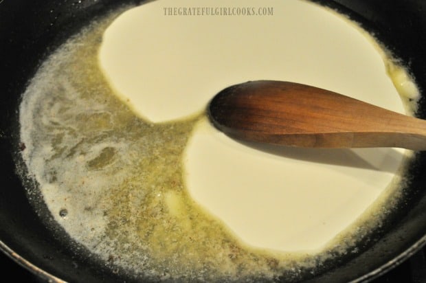 Butter and whipping cream in skillet to make sauce for bacon parmesan spinach quiche.