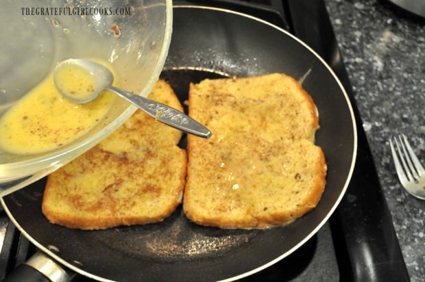 Remaining egg batter is spooned onto classic french toast in skillet.