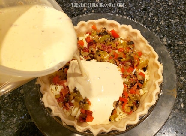 the eggs, cream and spices are poured into pie shell for Southwestern bacon quiche.