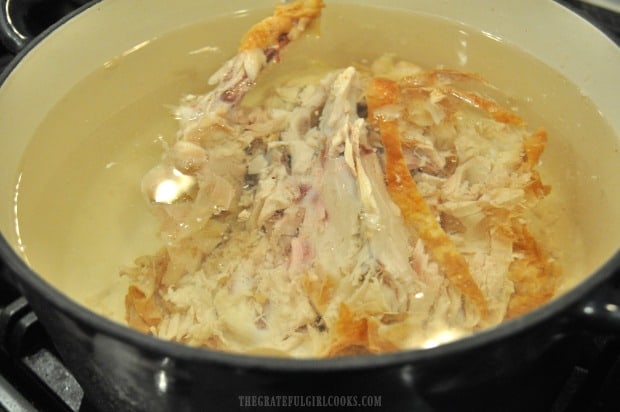 Leftover rotisserie chicken in pot of water to make chicken noodle soup.