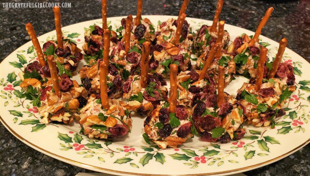 A pretzel stick is inserted into cranberry pecan goat cheese bites, to serve.