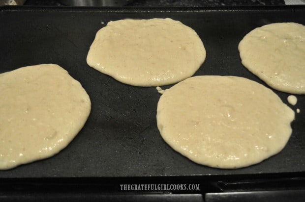 Apple pie pancakes cooking on electric grill.