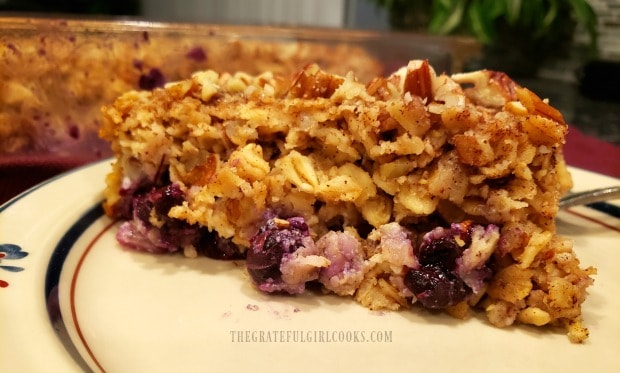 A close up view of a slice of blueberry apple pecan baked oatmeal on a plate.