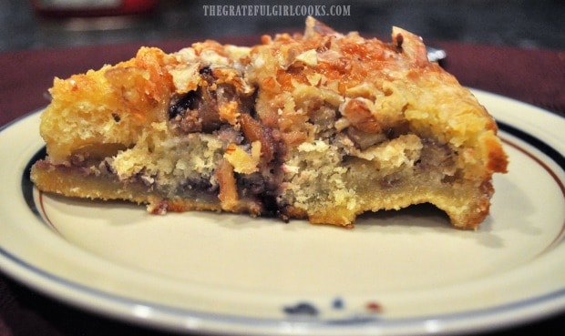 A slice of crescent roll coffeecake, on a plate, ready to be eaten!