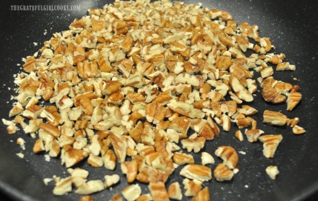 Chopped pecans are lightly toasted in skillet for cranberry orange Israeli couscous.