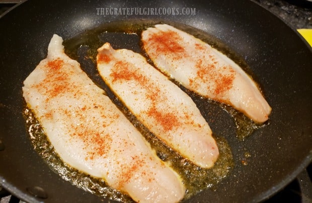 The lightly seasoned dover sole fillets are pan-seared in skillet.