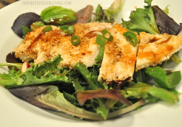 Sesame chicken salad with ginger dressing, served in a white bowl.