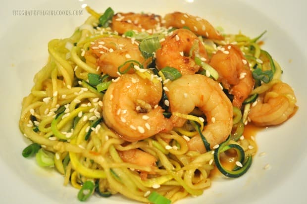 Sesame seeds and green onions garnish the sweet chili sesame shrimp zoodles.