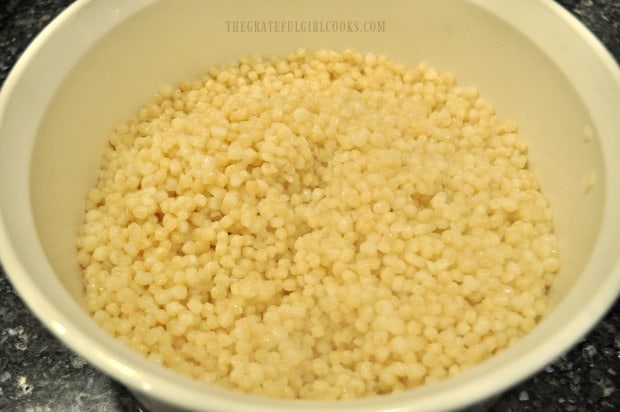 Israeli couscous cooked and drained, in bowl for cranberry orange couscous salad.