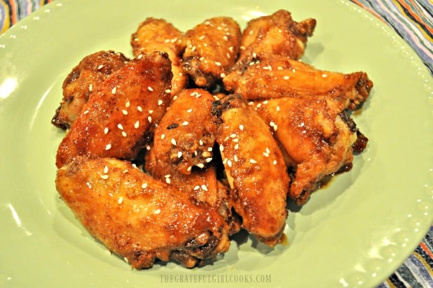 A green plate, with baked Asian chicken wings, is ready to serve and eat!