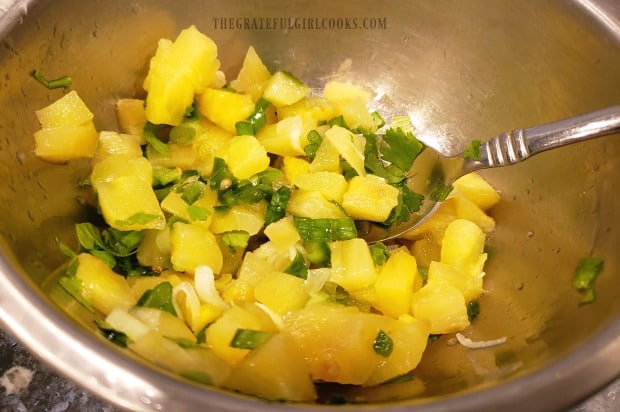 Pineapple salsa is mixed together to top broiled salmon.