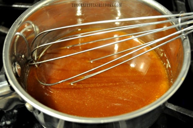 The buffalo honey sauce for the chicken wings simmering in a saucepan.