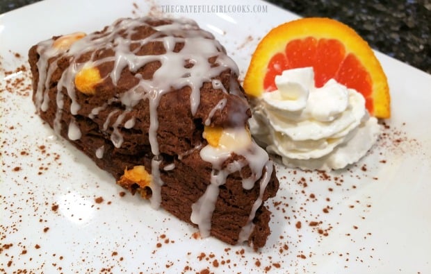 The double chocolate scone is served with a dollop of whipped cream and an orange slice.