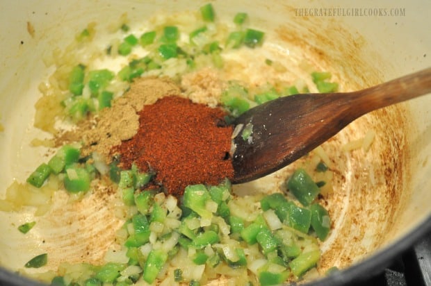 Spices for Southwestern chicken soup are added to onions, jalapeños and peppers in pan