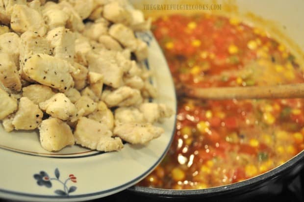 Cooked chicken pieces are added to the pot of Southwestern chicken soup.