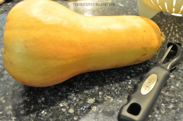 Butternut squash is ready to be peeled, seeded and cubed, to make maple cinnamon butternut squash.