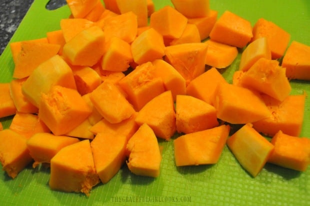 The butternut squash is peeled, seeded, then cut into bite sized pieces before baking.