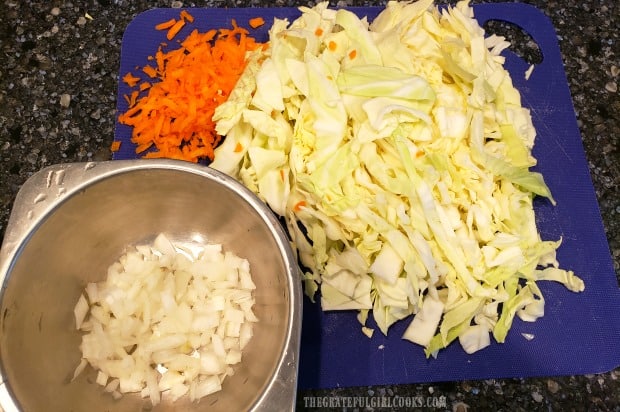 Chopped onions, shredded carrots and cabbage are ready to make fried cabbage.