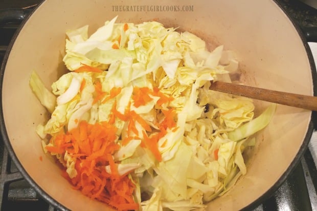 Shredded carrots and cabbage are added to bacon and onions to make fried cabbage.