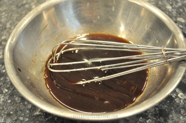 The ingredients for Asian sauce to coat the Thai turkey meatballs after baking is whisked in bowl.