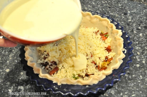 Egg and cream filling are poured over the quiche ingredients in the crust.