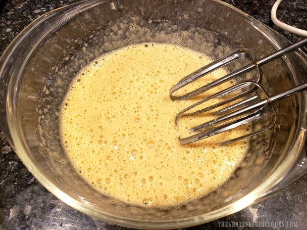 Batter for the banana blueberry pancakes is mixed in bowl.