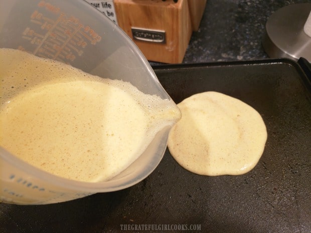 Batter is poured onto electric grill, to make 5 Weight Watchers Freestyle banana blueberry pancakes.