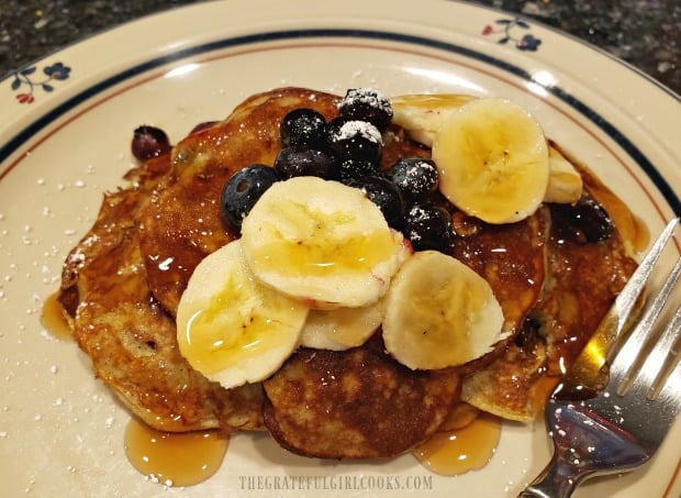 Banana blueberry pancakes, served with optional pancake syrup.