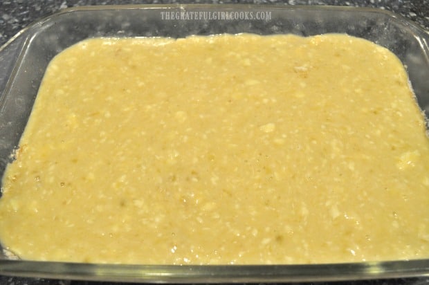 Half of the banana cake batter is poured into baking dish.