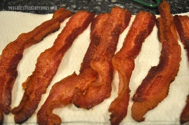 Cooked bacon is drained on paper towels before serving.