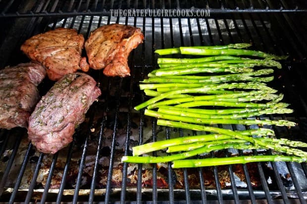 Grilled asparagus is placed directly on the BBQ grill, to cook.