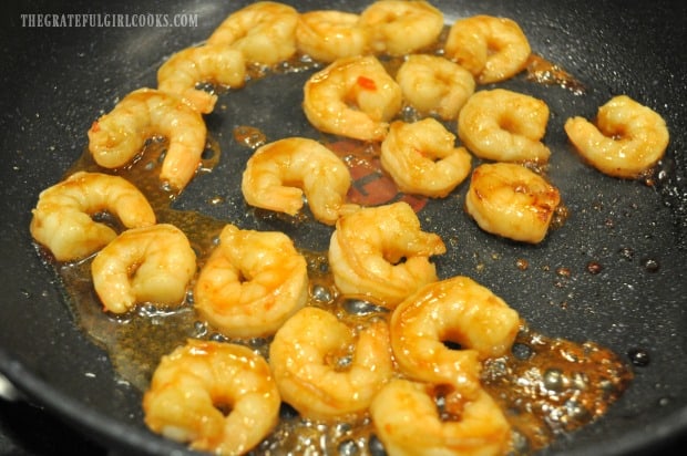 The marinated shrimp are pan-seared until done, in a skillet.