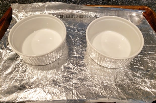 Ramekins are sprayed with non-stick baking spray, and placed on foil-covered baking sheet.