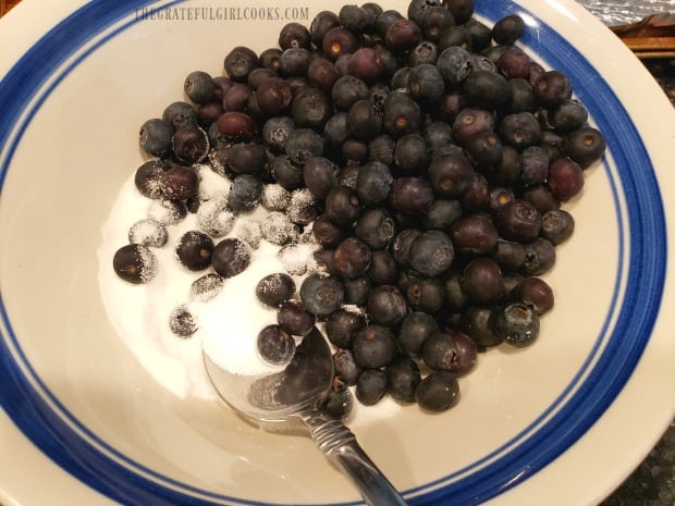 Fresh blueberries in a bowl with sugar, cornstarch and a pinch of salt.
