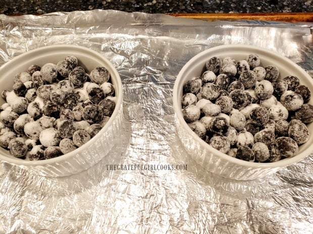 Two ramekins are filled with the sugar coated fresh blueberries.