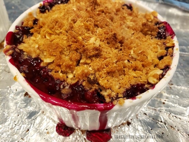 A close up photo of a baked streusel topped blueberry dessert.