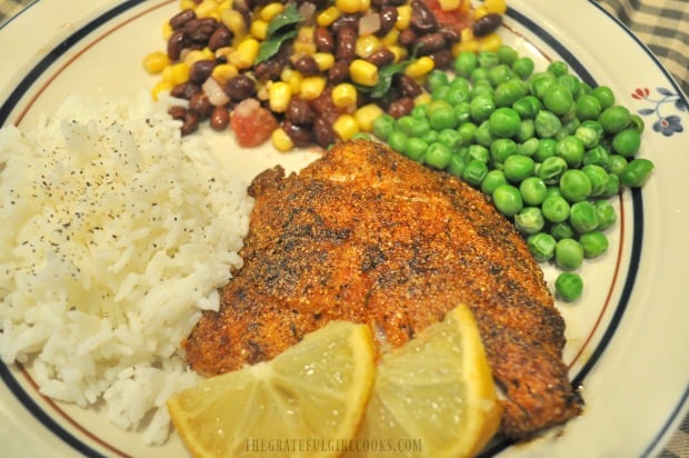 Lemon wedges garnish the finished cornmeal spice-crusted rockfish, served with rice and veggies.