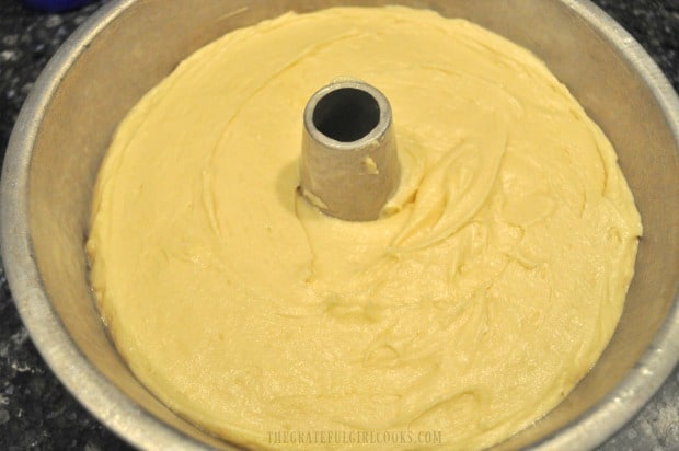 Batter for the butter cake is spread evenly in a tube pan before baking.