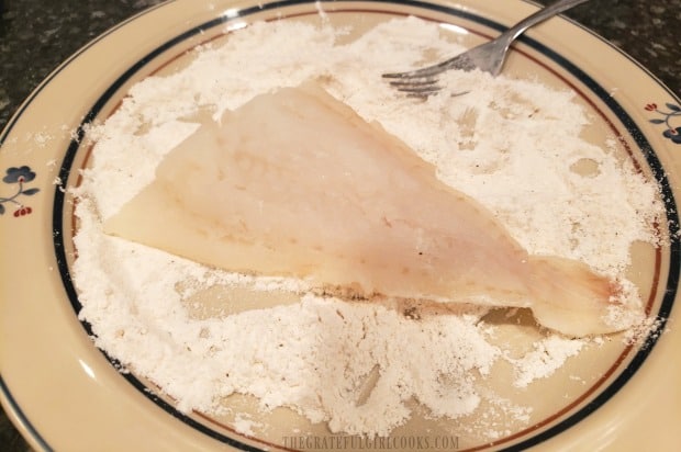 Cod fillets are dredged in flour and seasonings before cooking.