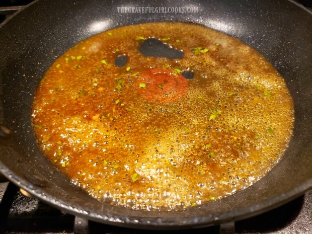 The glaze for the pork chops is cooked in the skillet until syrupy.